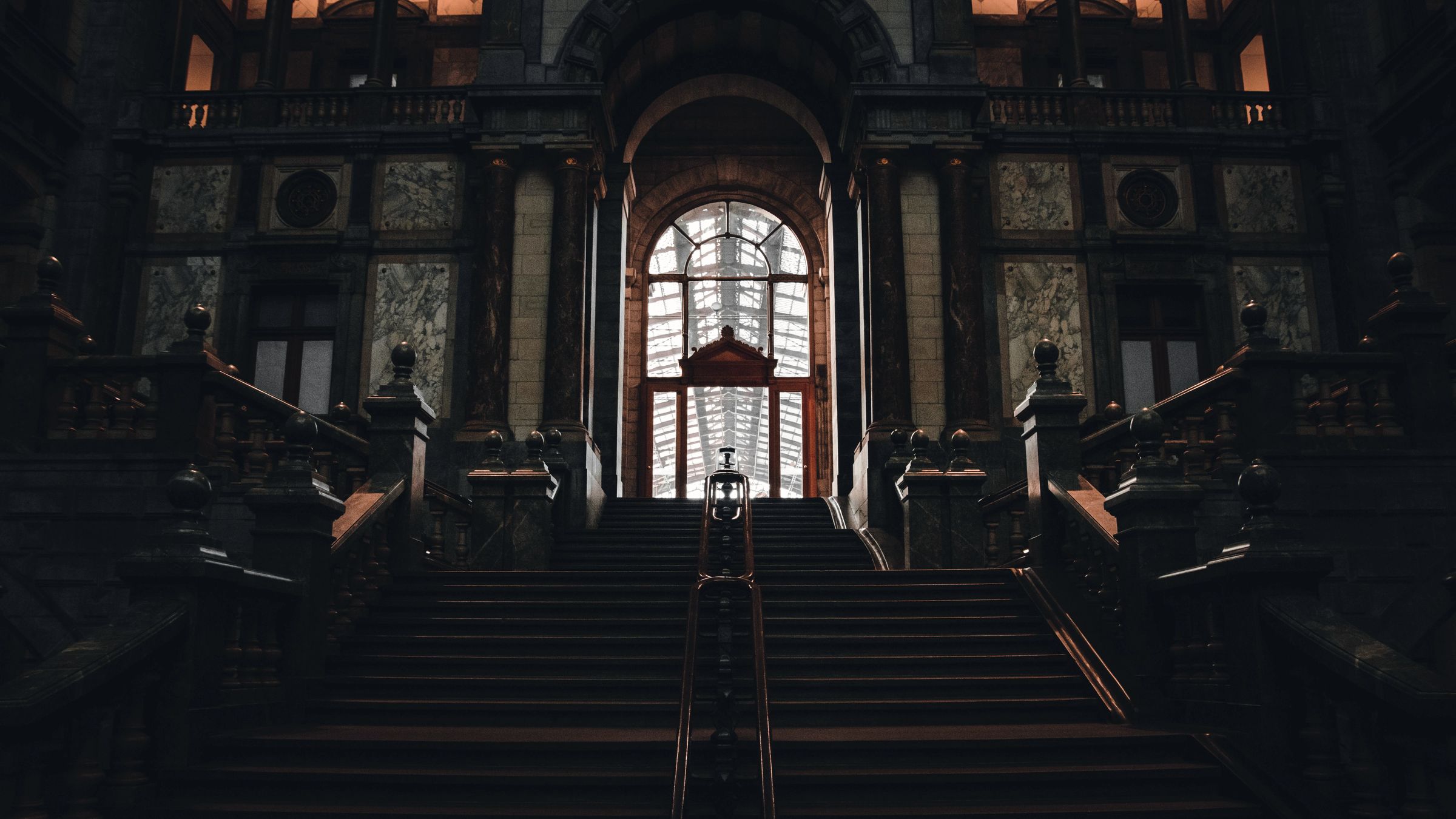 A grand staircase leading up to a lit doorway