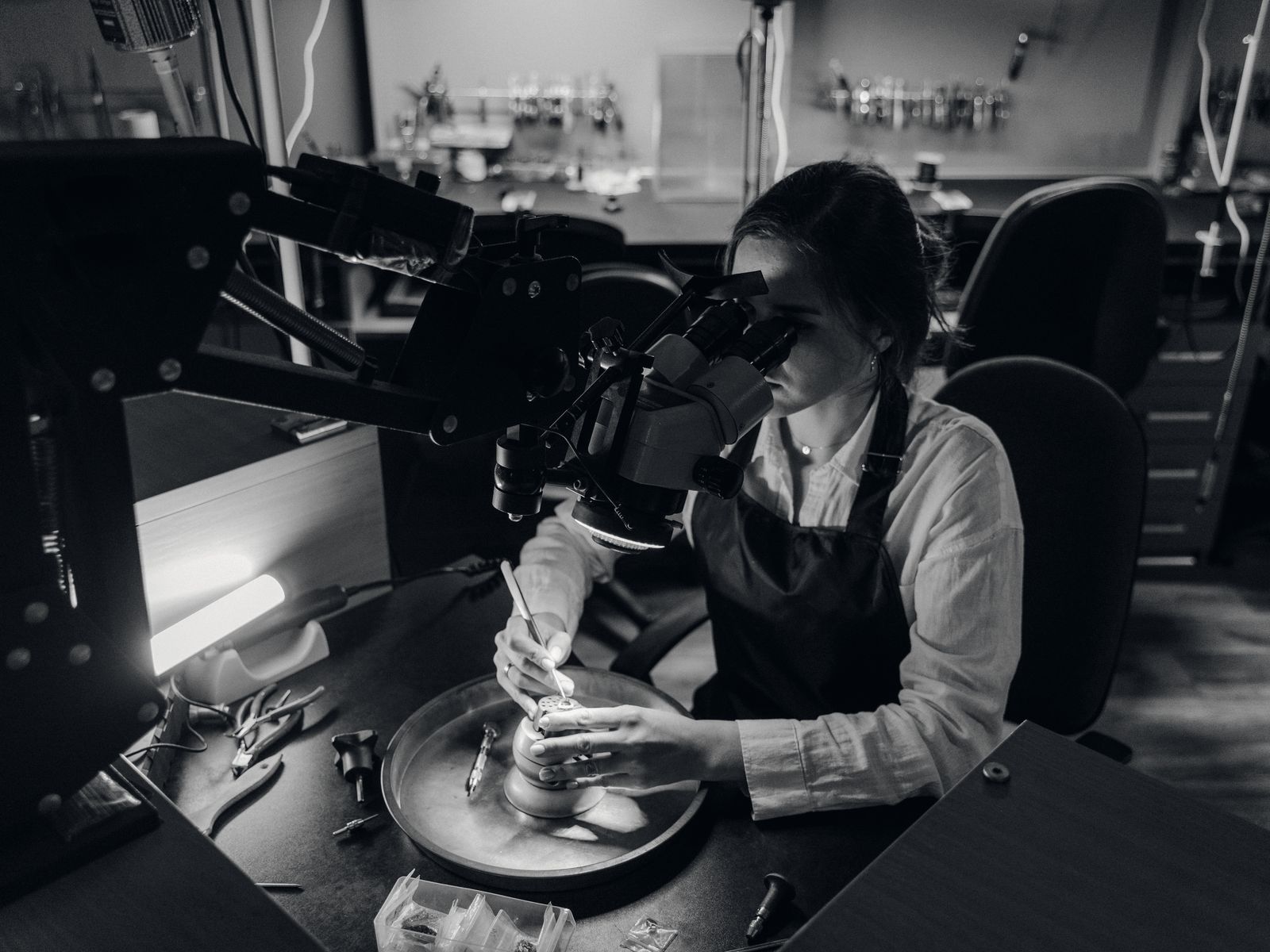 A gemologist examining a stone under a microscope